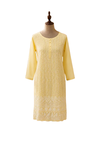A straight-cut knee-length cotton kurti displayed on a wooden dress mannequin. The garment is a soft pastel yellow color, decorated with fine, all-over white thread Lucknowi Chikankari embroidery. The design features vertical floral vine patterns down the front, a subtle front button placket at the round neckline, plain three-quarter sleeves, and a heavy geometric and floral embroidered border with a scalloped bottom edge.